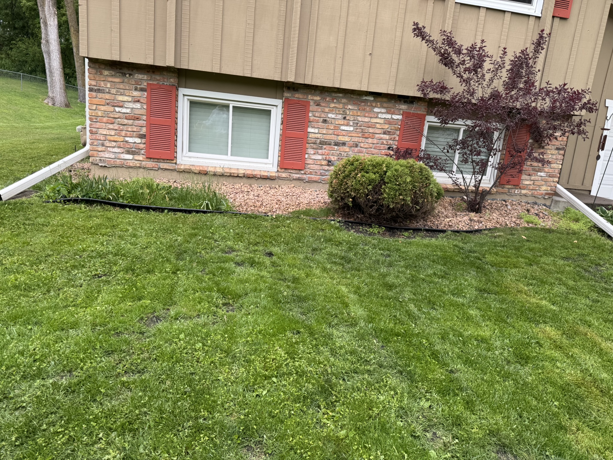 Front rock bed with sinking edging and weeds growing through before replacement in Minnetonka Minnesota