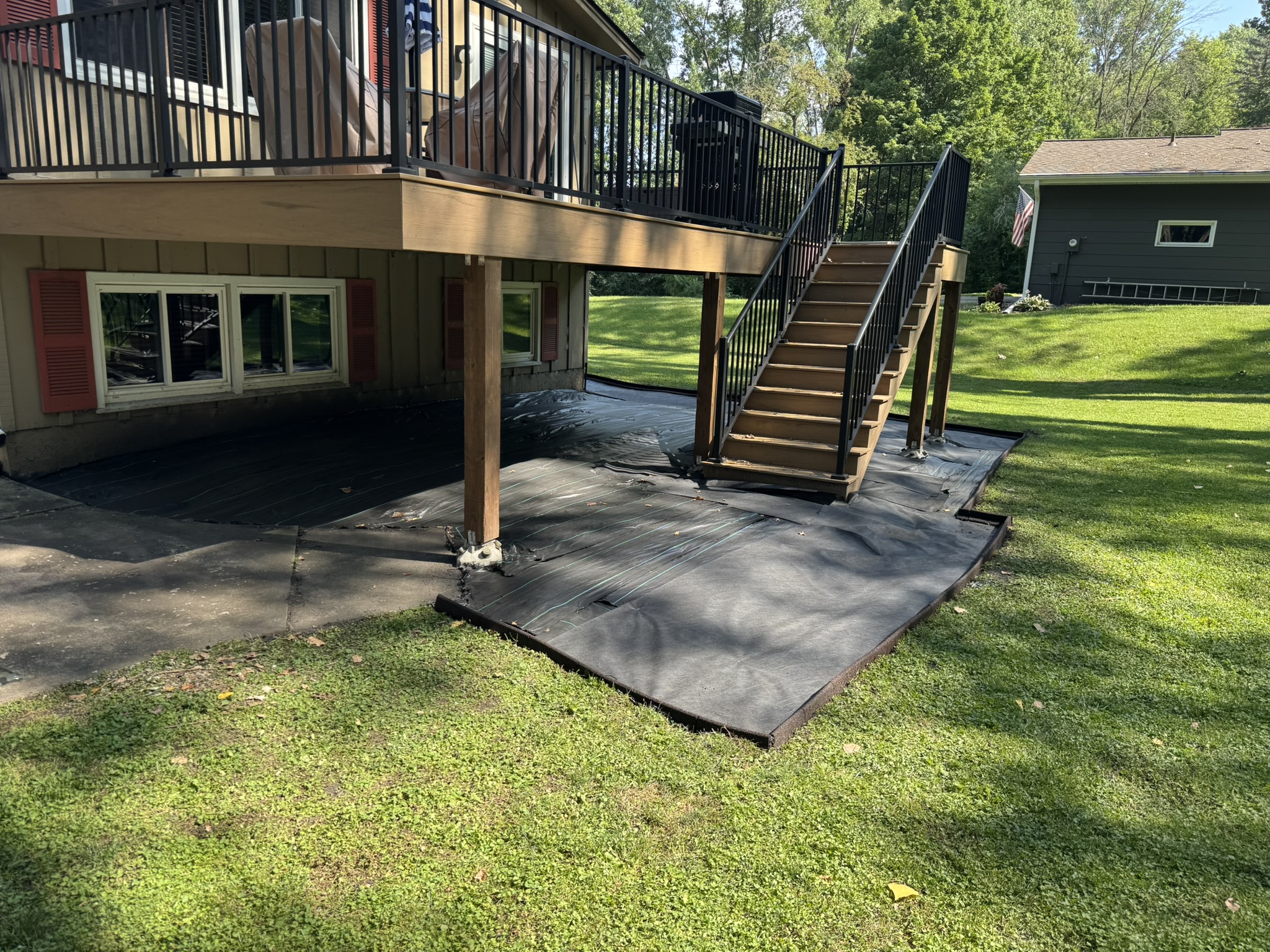 Landscape fabric and edging set along the slope of a backyard rock bed in Minnetonka Minnesota