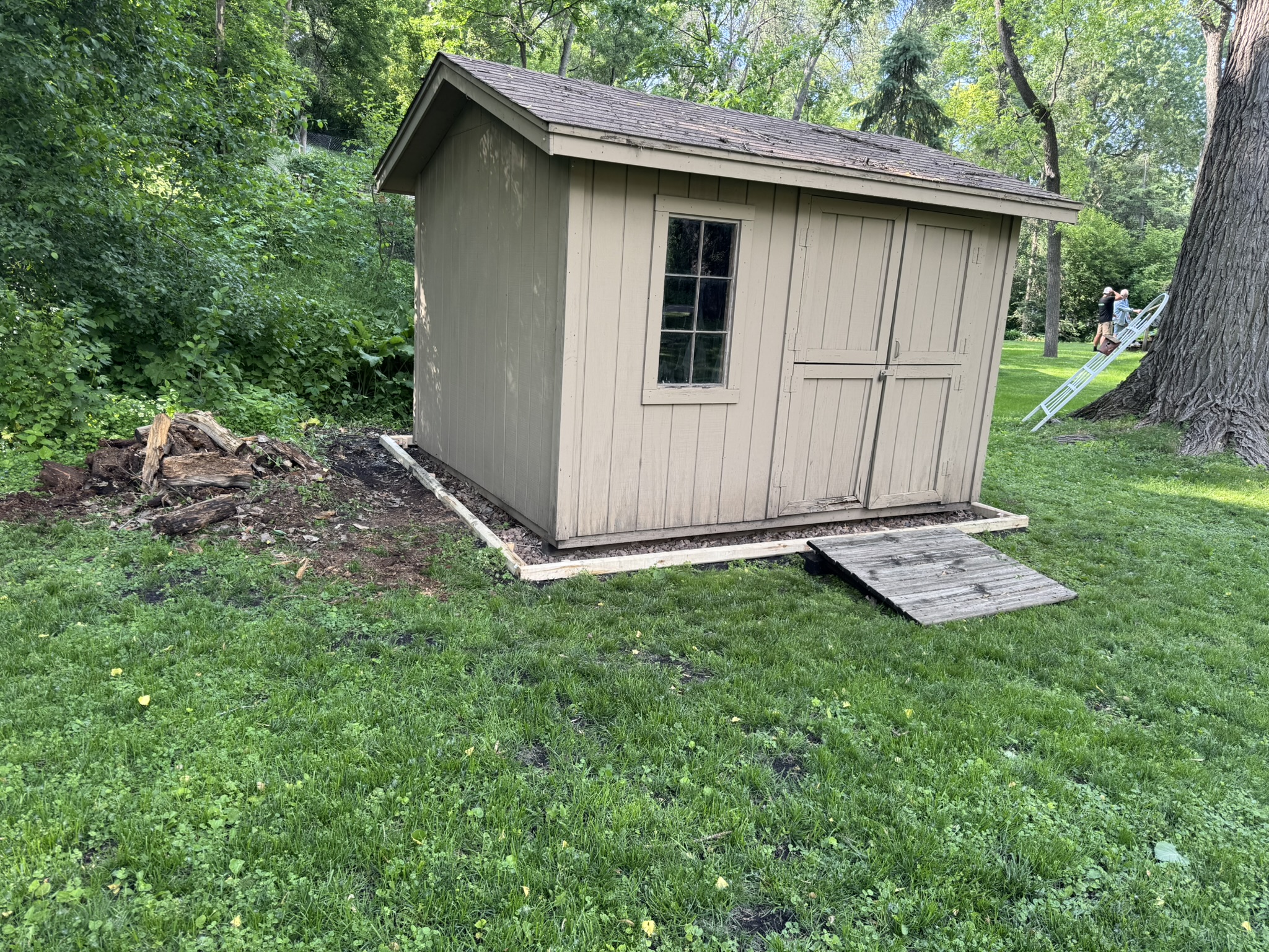 Storage shed set on a new timber frame and gravel pad with a wooden ramp in Minnetonka Minnesota